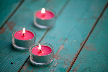 Burning candle on wooden background
