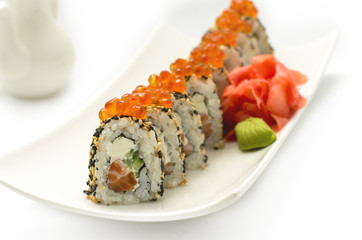 Суши из лосося, украшенный лососевой икры и семенами кунжута. Изолированные на белом фоне пластины.