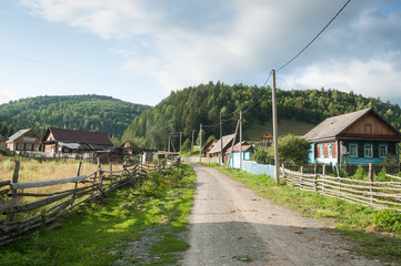 Dirty road through traditional russian village Assy