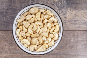 Cashew nuts in a bowl on wooden background