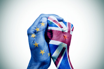 hands patterned with the European and the British flag put toget