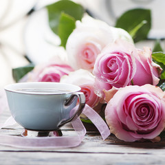 Pink roses and coffe on the wooden table