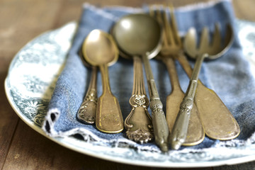 Old cutlery on a vintage plate.