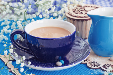 Cup of coffee with milk on a white wooden table