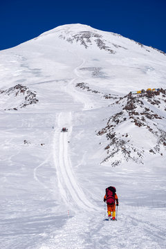 Climbing lone alpinist in the Caucasus mountains Elbrus, climb up the trail snowcat
