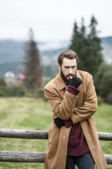 Fototapeta premium man in a brown coat and torn trousers