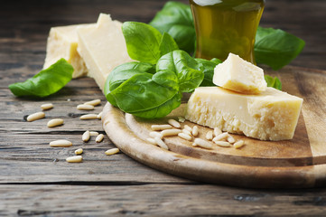 Basil, cheese, pine and olive oil on the wooden table