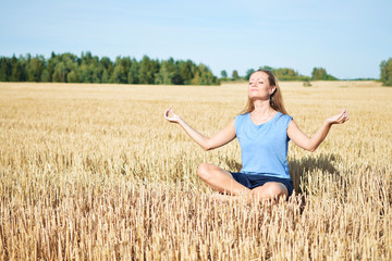 Young woman meditating in the field