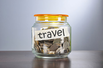 Saving concept of coins in the glass jar for travel  purpose