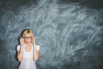 The young teacher near blackboard showing the right example