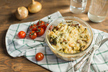 Tomato gratin with cheese and zucchini in baking dish