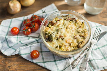 Tomato gratin with cheese and zucchini in baking dish