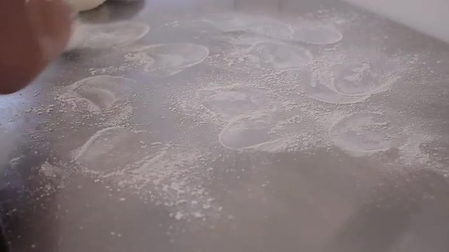 Flour being applied to polished metal surface in preparation of fondant