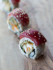 ahi tuna sushi rolls on a wooden cutting board with sesame seeds