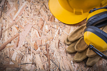 Safety leather gloves hard hat ear muffs on OSB