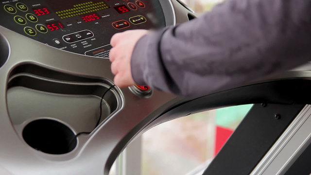 Man warming up before workout in the gym, male athlete walking on treadmill 