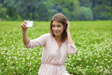 Fototapeta premium Young beautiful blonde woman photographing themselves on a cell
