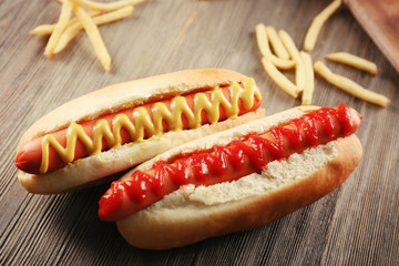 Hot dogs with fried potatoes on wooden background