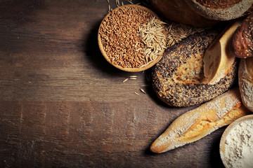 Fresh baked bread, flour and wheat on the wooden background