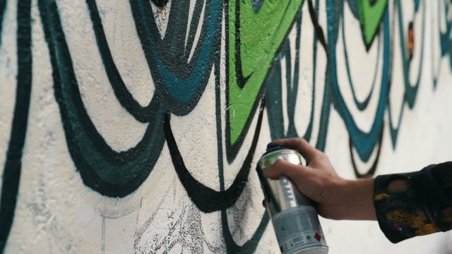Graffiti artist drawing on the wall, close up, slow motion