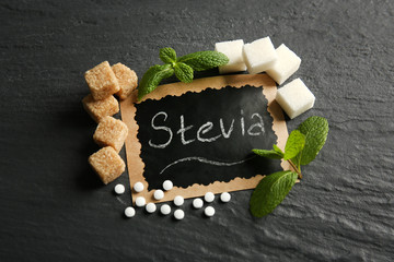 Word STEVIA in sugar frame on black background, close up