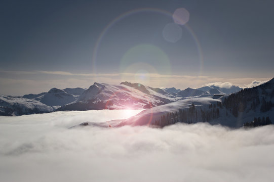 Fototapeta Über den Wolken - Bergpanorama Tirol im Winter mit Lens flare - Kitzbüheler Alpen, Tirol, Österreich