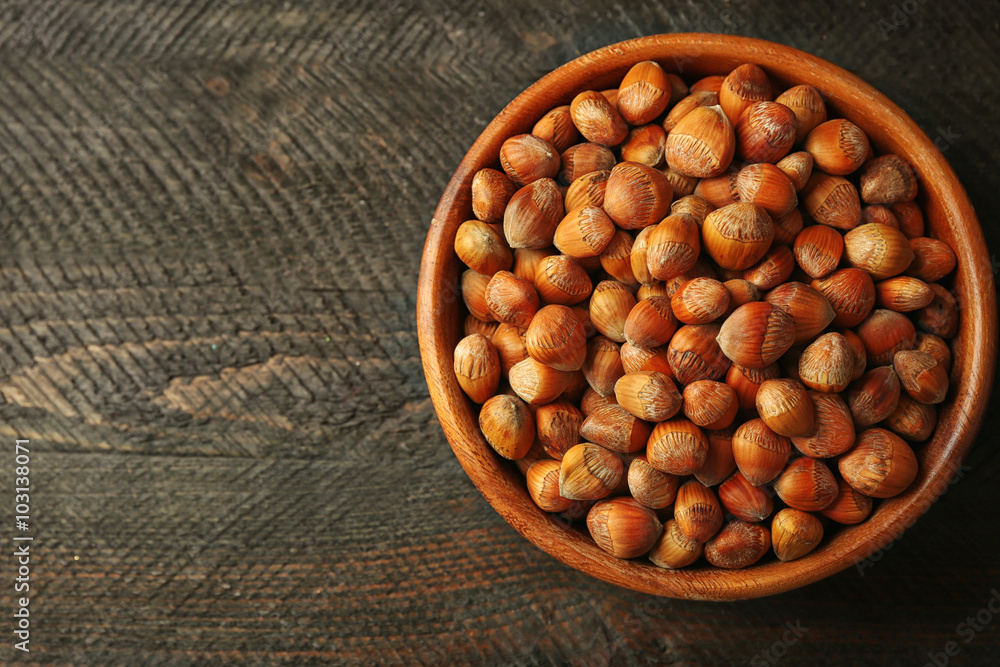 Wall mural Hazelnuts in the bowl on the wooden table