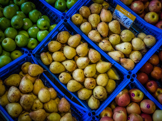 Pears and apples on sale in baskets