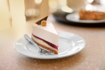 Delicious cheesecake in sauce on table closeup