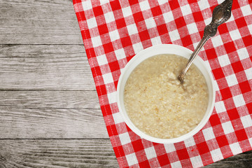 White bowl of oatmeal with a spoon