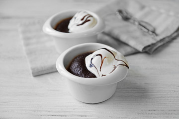Chocolate lava cake with ice-cream in bowls, on the table