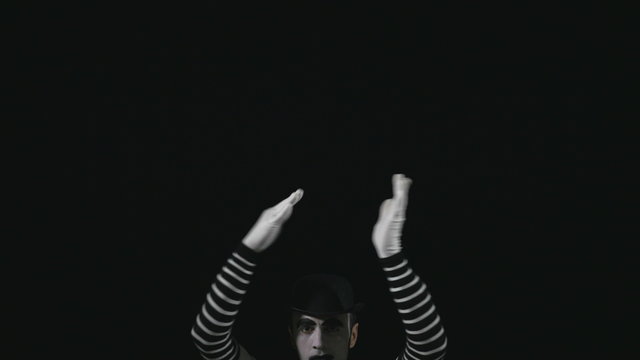 Young funny mime climbing and performing a pantomime act