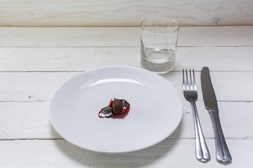 white plate with a small chocolate Easter egg in open red foil,