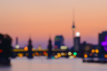 Fototapeta premium streszczenie niewyraźne tło Berlina z wieży telewizyjnej, Oberbaumbruecke i rzeki Szprewy na wieczór, Niemcy, Europa