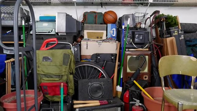 Vintage junk filled garage dolly out shot.  Object brand names and logos were covered.