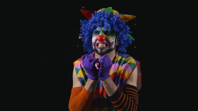 Young hilarious clown bursting into an evil laugh
