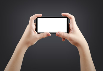 Two hands holding big screen smart phone, isolated on dark background, clipping path