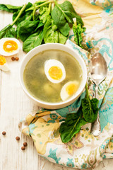 
healthy lunch , green soup with sorrel or spinach , boiled egg and spices on wooden background