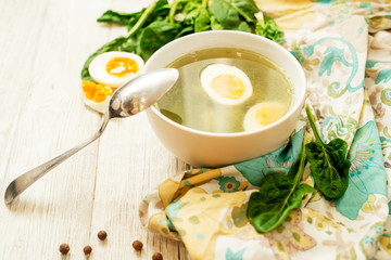 
healthy lunch , green soup with sorrel or spinach , boiled egg and spices on wooden background