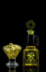 Olives and oil in a glass container.