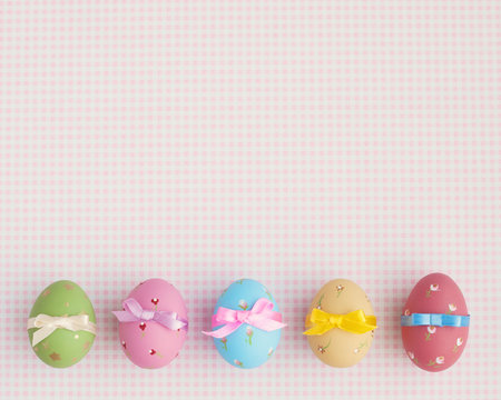 Vintage pastel easter eggs with ribbon over checkered background
