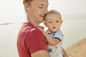 Portrait father with toddler son playing on the beach