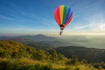 Hot air balloon above high mountain at sunset