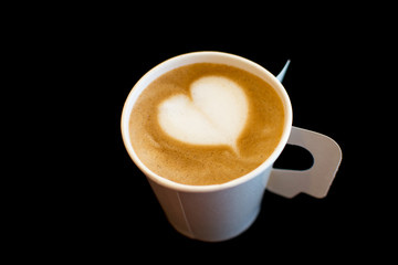 A paper cup of coffee with heart shape on Black background