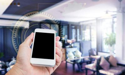 Hand holding blank screen mobile phone with business graphics co