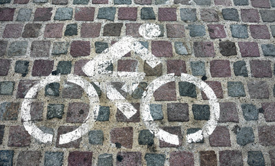 Bike riding allowed sign painted on brick street