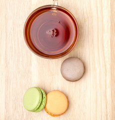 Macaroons and glass cup of black tea.Above view