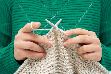 Close-up of young woman hands, knitting scarf