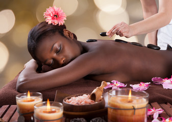 Relaxed Woman Receiving Hot Stone Therapy