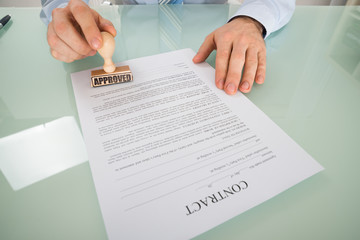 Businessman Stamping On Contract Form